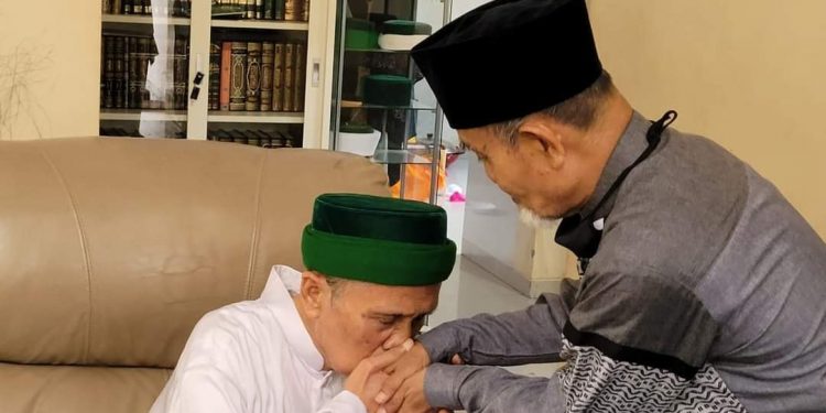 KH. Masbuchin mencium tangan KH. Hasan Abdullah Sahal. KH. Masbuchin memberi hormat pada KH. Hasan Abdullah Sahal karena KH. Hasan Abdullah Sahal adalah putra gurunya; KH. Ahmad Sahal. Foto. Alma'arif Arif