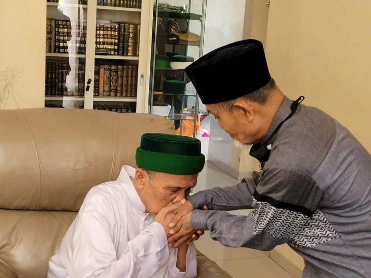 KH. Masbuchin mencium tangan KH. Hasan Abdullah Sahal. KH. Masbuchin memberi hormat pada KH. Hasan Abdullah Sahal karena KH. Hasan Abdullah Sahal adalah putra gurunya; KH. Ahmad Sahal. Foto. Alma'arif Arif